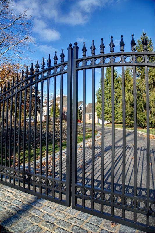 Black ornamental driveway gates with arched tops, spearhead finials and circular details