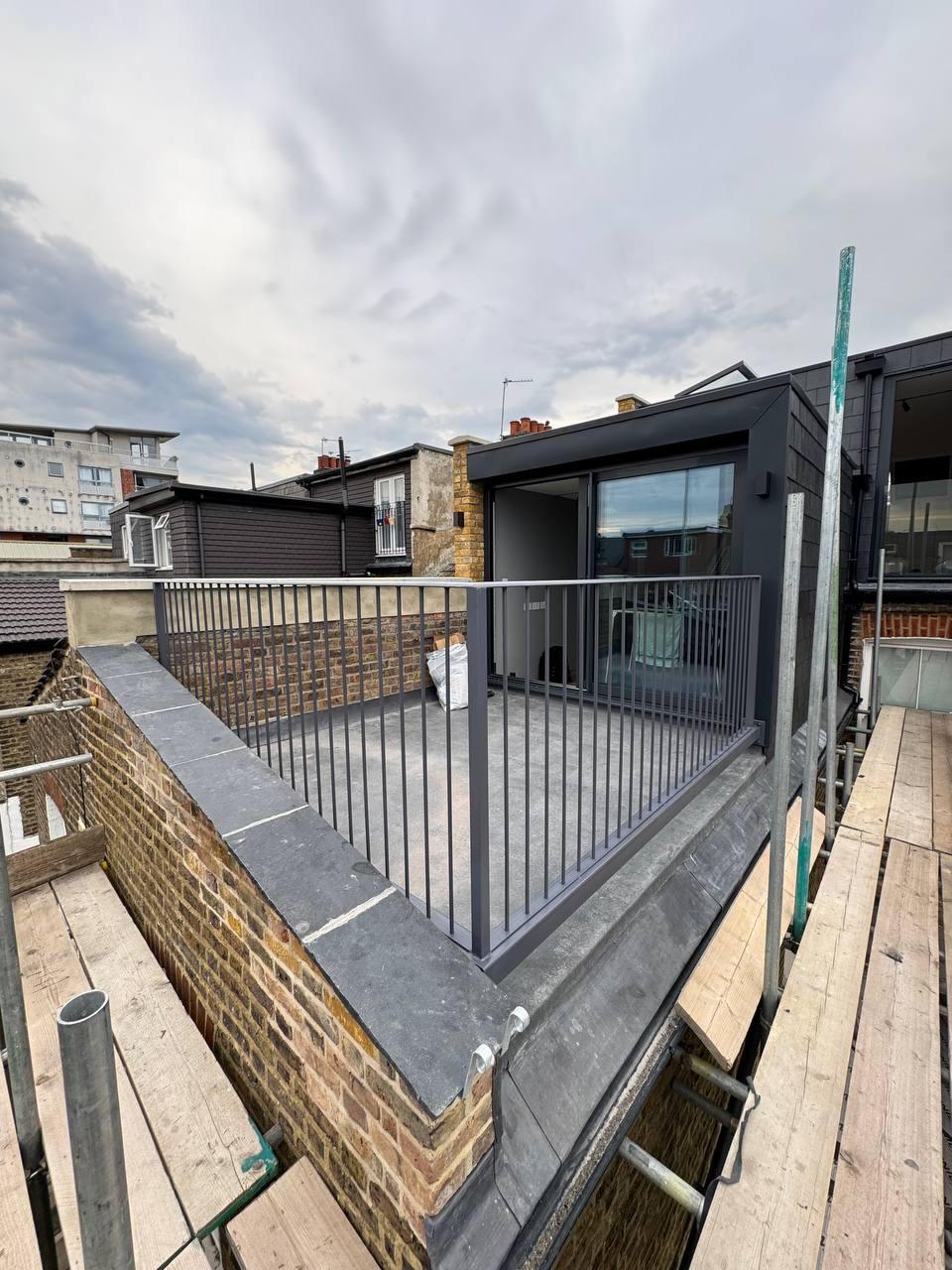 Grey vertical-bar metal railings installed around a rooftop terrace