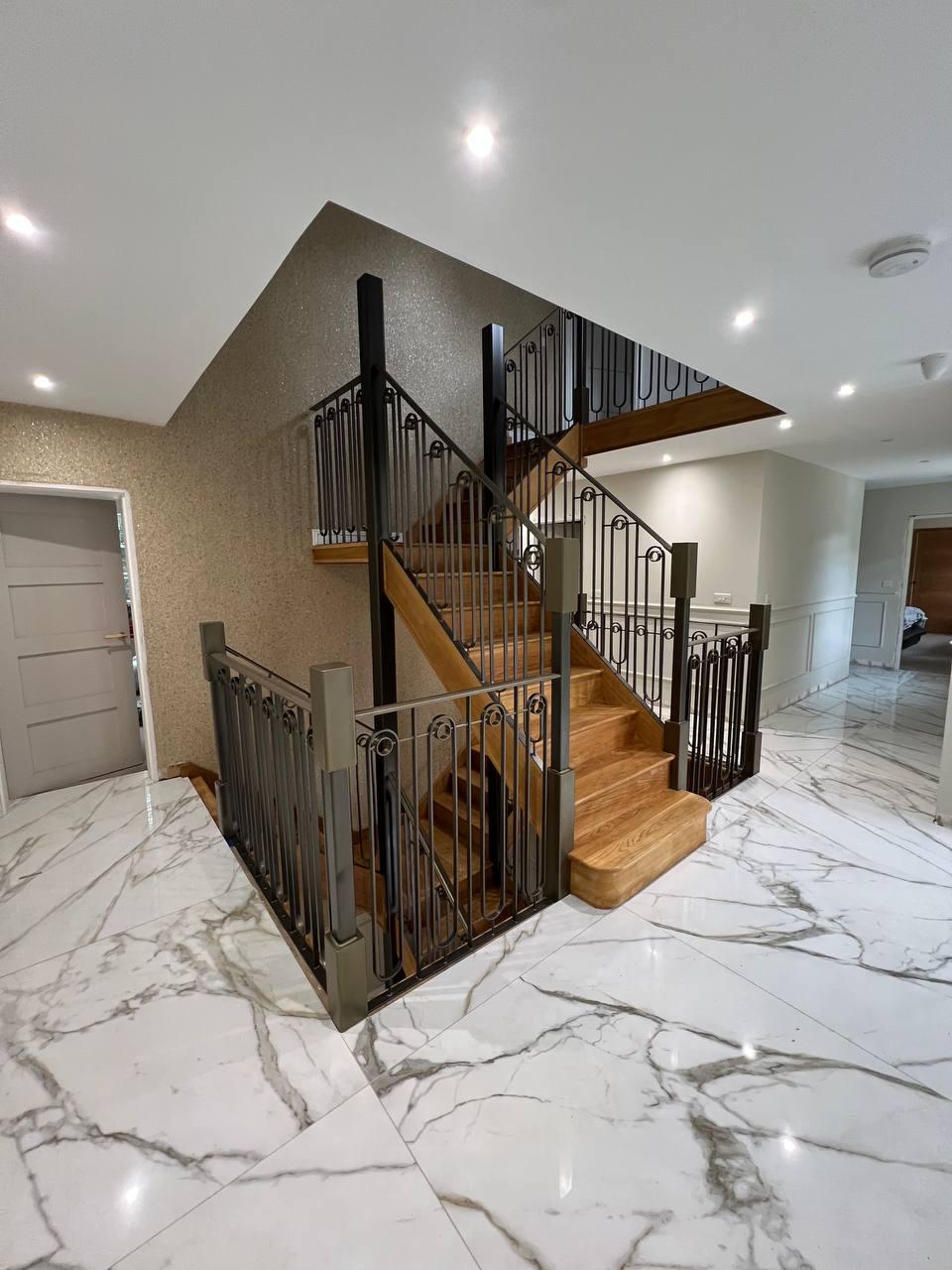 Full view of the multi-level timber staircase with decorative black balustrades and landing guarding