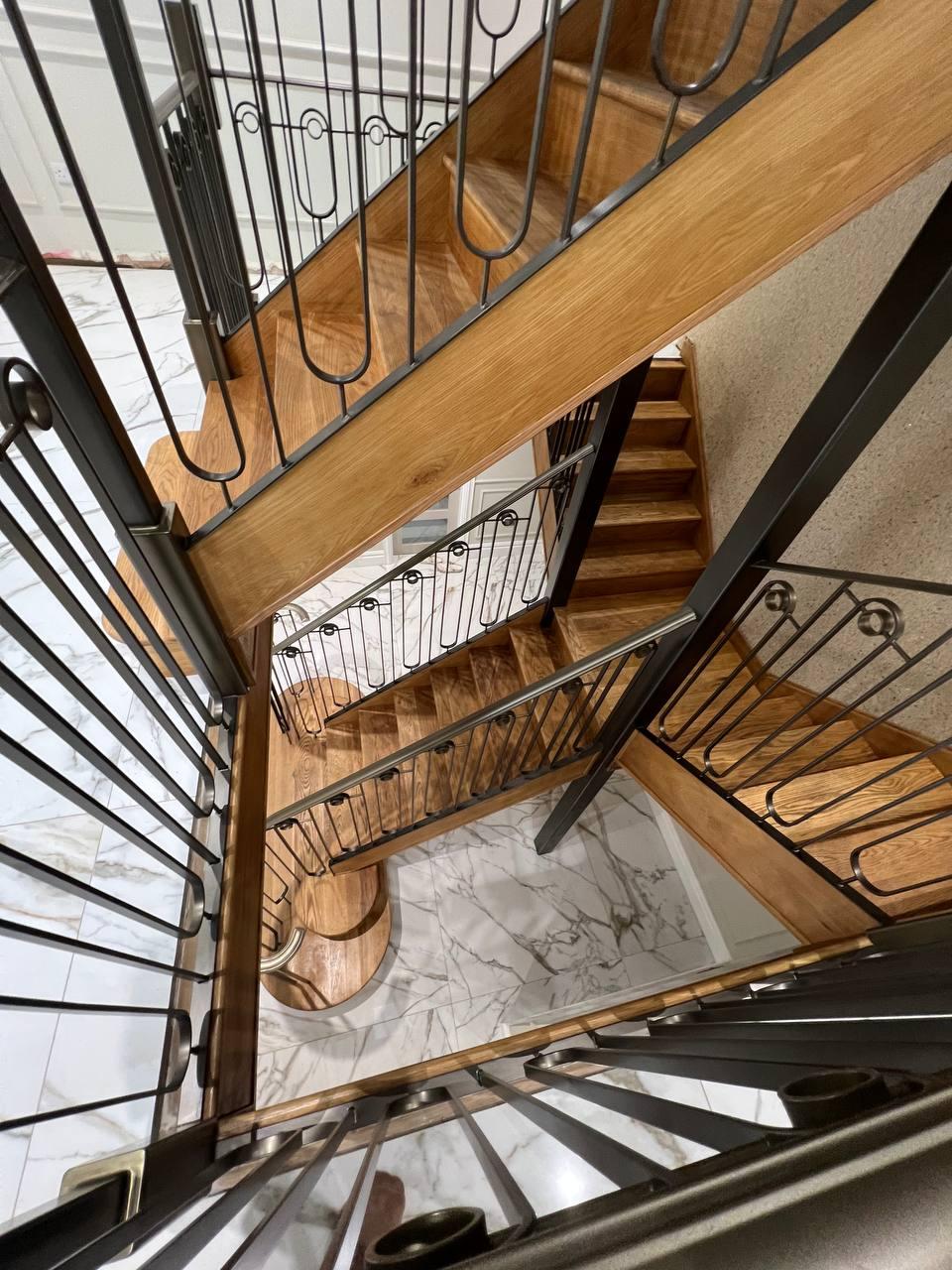 View down through the stairwell showing the connected decorative balustrades across multiple flights