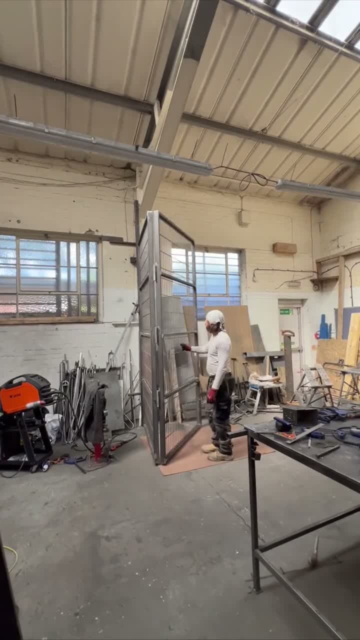 Workshop demonstration of the four-leaf driveway gate folding inward to reduce its opening space