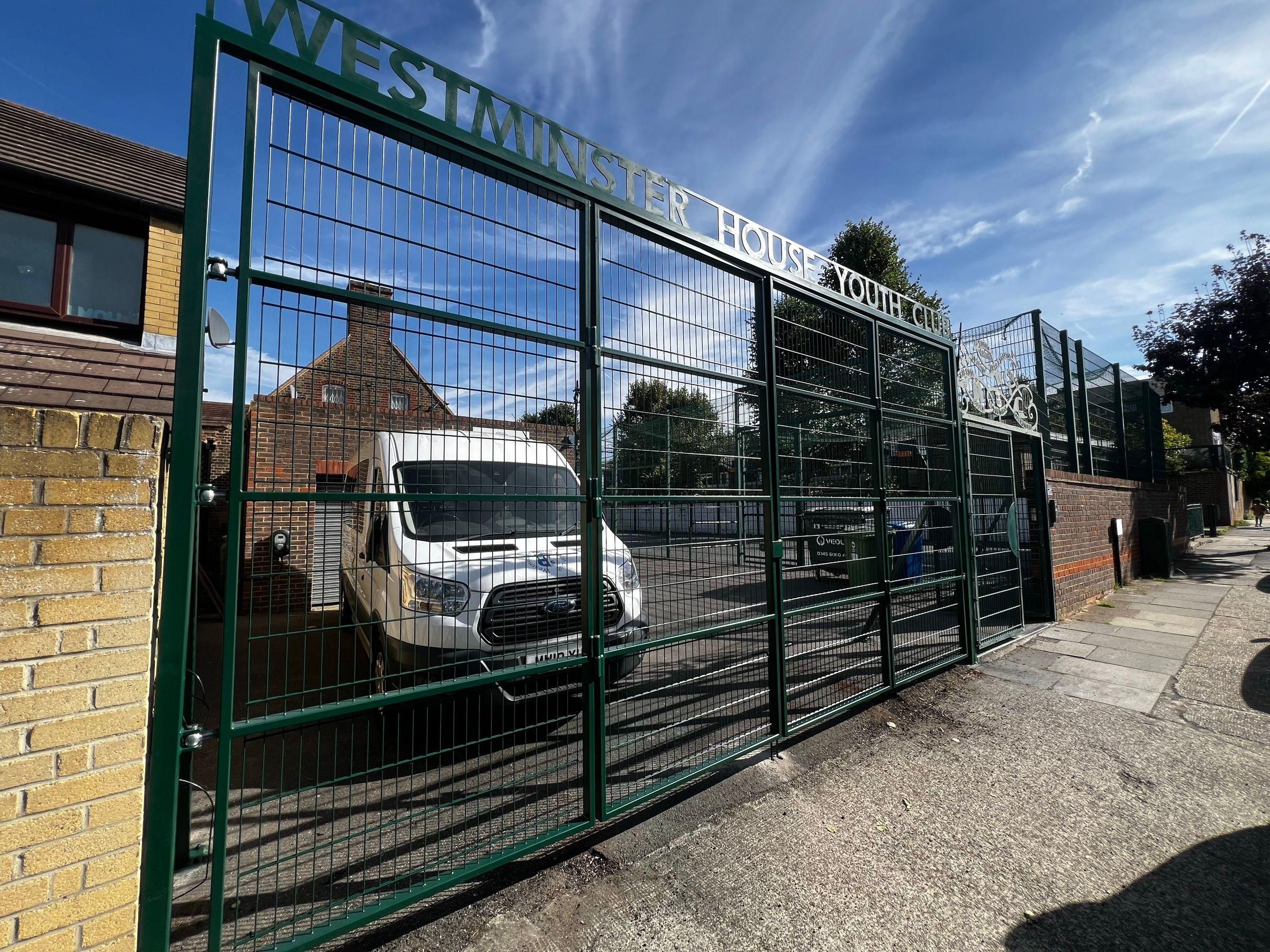 Finished green four-leaf mesh bifold driveway gates at Westminster House Youth Club
