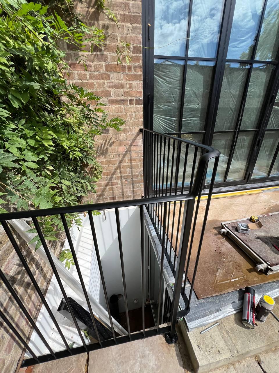 Close view of black vertical-bar guarding around the exterior stair opening